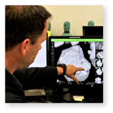 Image of an AvMC engineer pointing to a screen with visual information displayed